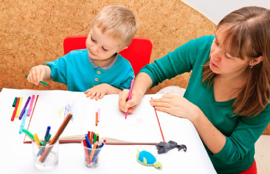 Child with teacher drawing in playroom