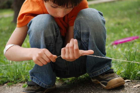 Little boy playing with string